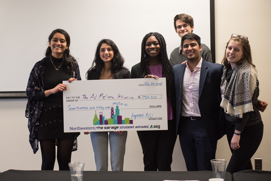 Winners of the Improve NU challenge holding their check
